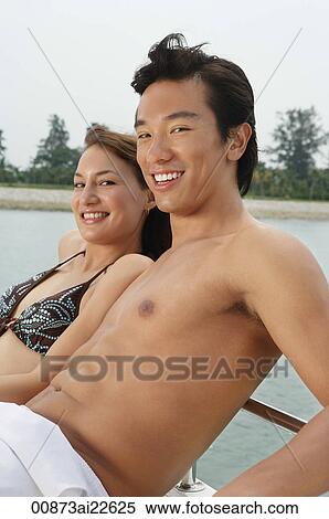 Stock Photography - Young couple on yacht, smiling at camera. Fotosearch