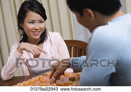 Stock Image - Young couple playing board game. Fotosearch