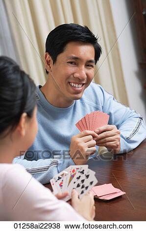 Stock Photo - Young couple playing cards. Fotosearch