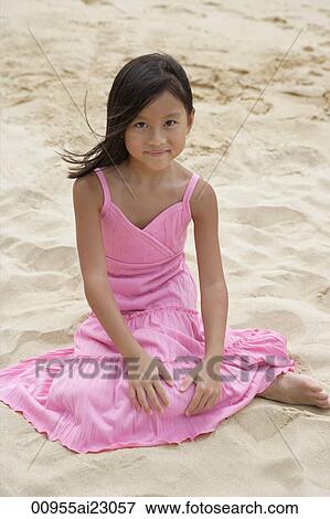 Young girl sitting in the sand and smiling at camera View Large Photo Image Stock Photo - Young girl sitting in the sand and smiling at camera. Fotosearch