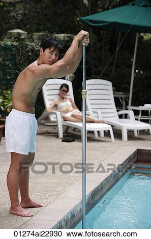 Young man cleaning swimming pool View Large Photo Image Stock Image - Young man cleaning swimming pool. Fotosearch