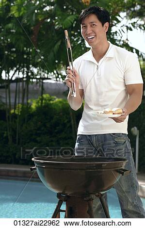Young man having a barbeque View Large Photo Image Stock Image - Young man having a barbeque. Fotosearch