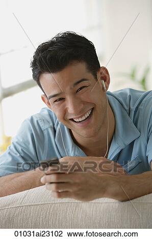 Young man listening to music View Large Photo Image Stock Image - Young man listening to music. Fotosearch