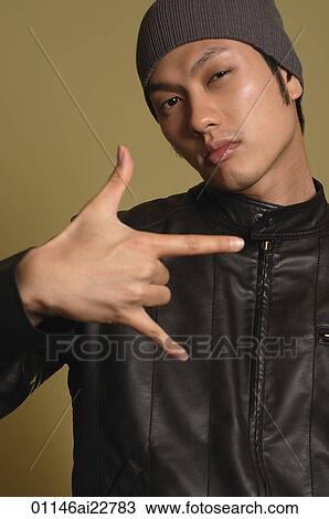 Stock Image - Young man looking at camera, making gesture. Fotosearch