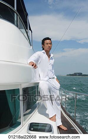Young man on yacht, looking into distance View Large Photo Image Stock Photo - Young man on yacht, looking into distance. Fotosearch