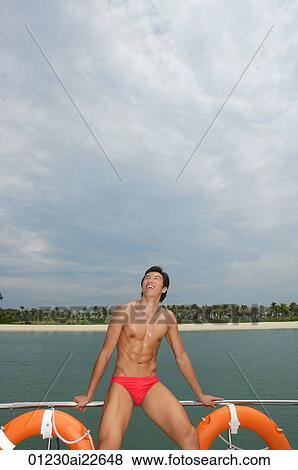 Young man on yacht, looking up View Large Photo Image Stock Photo - Young man on yacht, looking up. Fotosearch