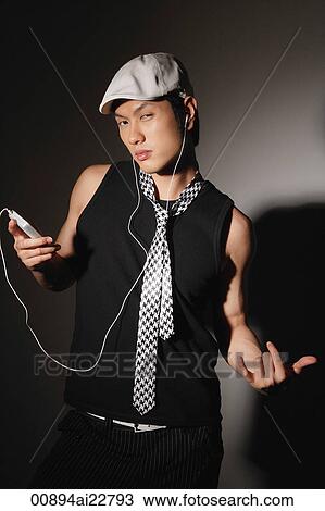 Young man posing while listening to music View Large Photo Image Stock Image - Young man posing while listening to music. Fotosearch