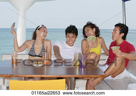 Young people playing cards on yacht View Large Photo Image Stock Image - Young people playing cards on yacht. Fotosearch