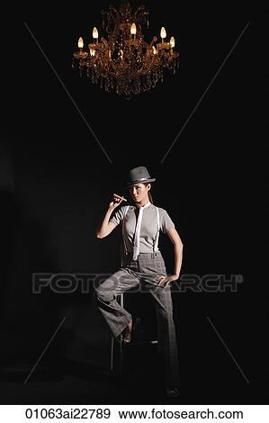 Stock Photo - Young woman in suit outfit posing with cigar. Fotosearch