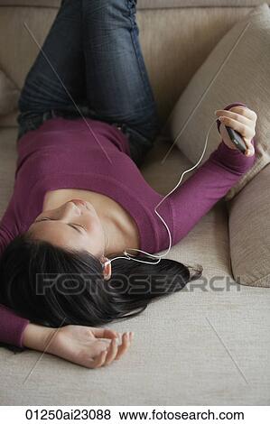 Stock Photo - Young woman listening to music. Fotosearch