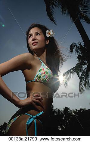 Stock Image - Young woman on beach in bikini. Fotosearch