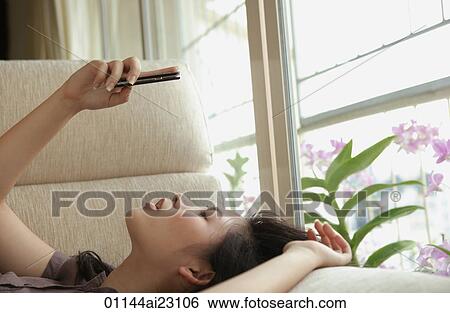 Stock Photograph - Young woman using mobile phone. Fotosearch