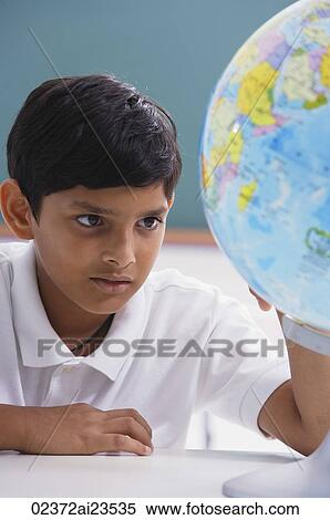 boy looks at globe, one hand on globe View Large Photo Image Stock Photography - boy looks at globe, one hand on globe. Fotosearch