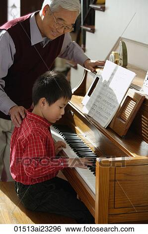 Boy playing piano for grandfather View Large Photo Image Stock Photograph - Boy playing piano for grandfather. Fotosearch