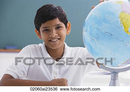 boy smiles at camera with globe View Large Photo Image Stock Photograph - boy smiles at camera with globe. Fotosearch