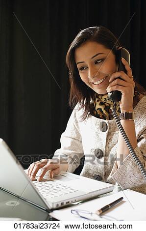 business woman working at laptop, on phone View Large Photo Image Picture - business woman working at laptop, on phone. Fotosearch