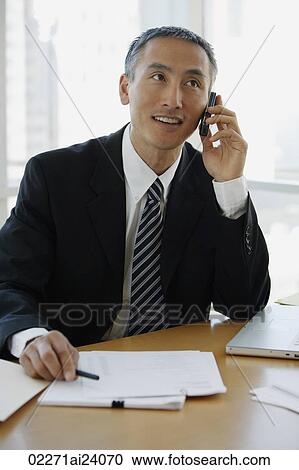 businessman at desk, talking on cellphone View Large Photo Image Stock Image - businessman at desk, talking on cellphone. Fotosearch