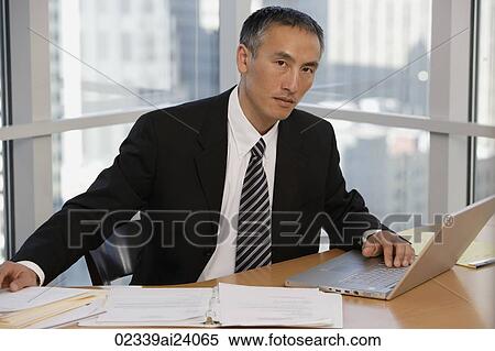 Stock Photography - businessman at table with laptop. Fotosearch