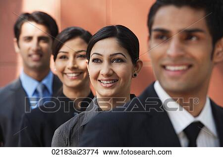 businessman in foreground, three colleagues in background, all smiling View Large Photo Image Picture - businessman in foreground, three colleagues in background, all smiling. Fotosearch