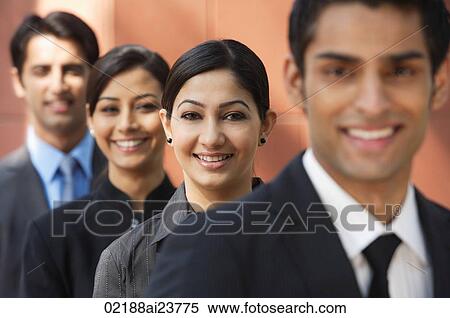 businessman in foreground, three colleagues in background, all smiling and looking at camera View Large Photo Image Stock Photography - businessman in foreground, three colleagues in background, all smiling and looking at camera. Fotosearch