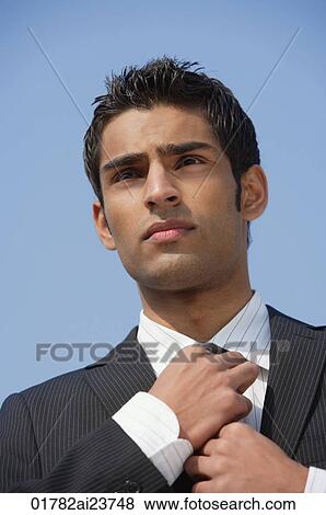 Stock Photo - businessman straightens his tie. Fotosearch