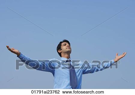 Stock Image - businessman with arms outstretched, eyes closed. Fotosearch