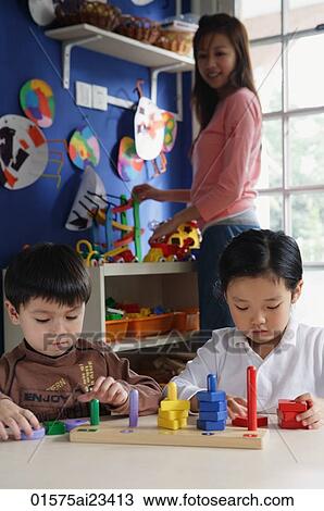 Stock Image - Children playing with stacking blocks. Fotosearch