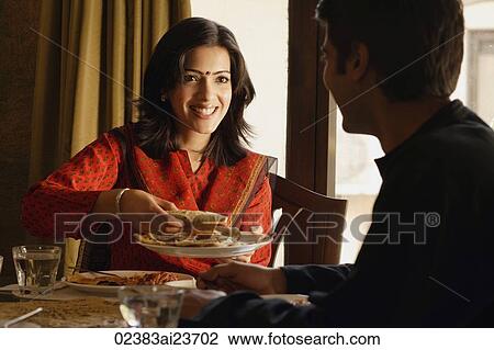 couple at dinner table, woman offering food View Large Photo Image Stock Image - couple at dinner table, woman offering food. Fotosearch
