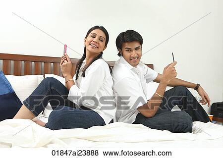 Stock Photo - Couple back to back on bed. Fotosearch