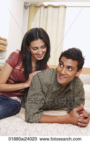 Stock Image - couple lounging on bed. Fotosearch