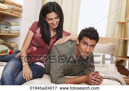 Stock Photo - couple lounging on bed. Fotosearch