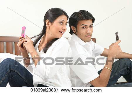 Couple texting each other View Large Photo Image Stock Photo - Couple texting each other. Fotosearch
