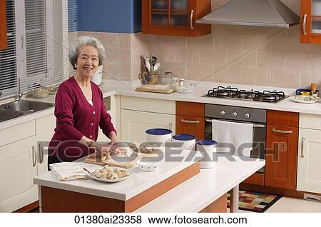 Elderly woman baking in the kitchen View Large Photo Image Stock Photo - Elderly woman baking in the kitchen. Fotosearch