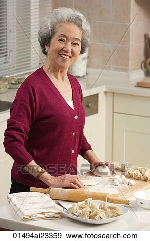 Elderly woman baking in the kitchen View Large Photo Image Stock Photo - Elderly woman baking in the kitchen. Fotosearch
