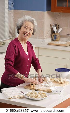 Elderly woman baking in the kitchen View Large Photo Image Stock Photo - Elderly woman baking in the kitchen. Fotosearch