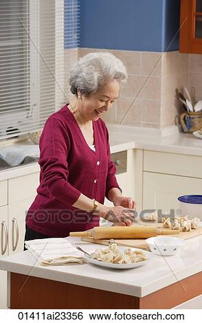 Elderly woman baking in the kitchen View Large Photo Image Stock Photograph - Elderly woman baking in the kitchen. Fotosearch