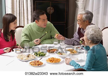 Family at dinner table having traditional food View Large Photo Image Stock Image - Family at dinner table having traditional food. Fotosearch