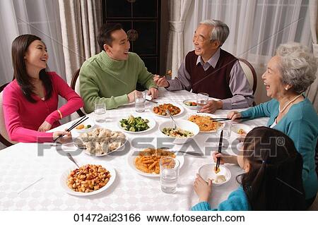 Family at dinner table having traditional food View Large Photo Image Stock Photograph - Family at dinner table having traditional food. Fotosearch