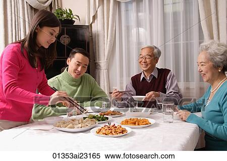 Family at dinner table having traditional food View Large Photo Image Stock Photography - Family at dinner table having traditional food. Fotosearch