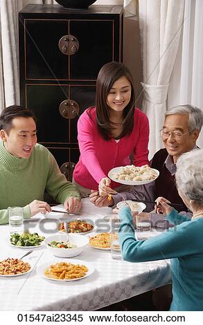 Family at dinner table having traditional food View Large Photo Image Stock Photography - Family at dinner table having traditional food. Fotosearch