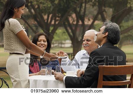 Stock Image - family having meal outdoors. Fotosearch