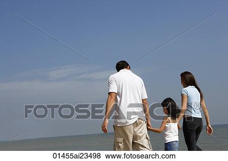 Stock Photo - Family holding hands, walking down the beach. Fotosearch