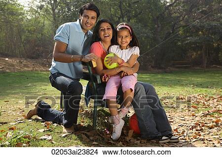 Family in park, girl holding yellow balloon View Large Photo Image Picture - Family in park, girl holding yellow balloon. Fotosearch