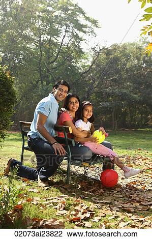 Family on park bench, red ball View Large Photo Image Stock Image - Family on park bench, red ball. Fotosearch