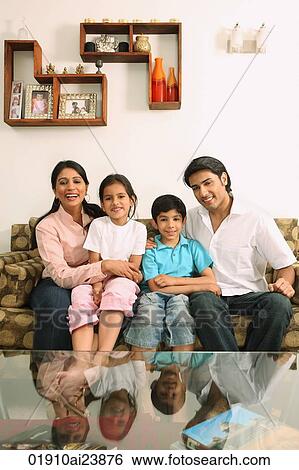 Stock Photograph - Family sitting on couch. Fotosearch