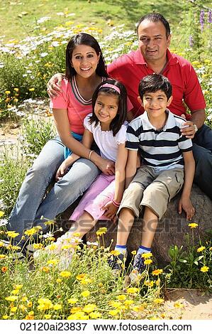 Stock Photo - family sitting on rock. Fotosearch