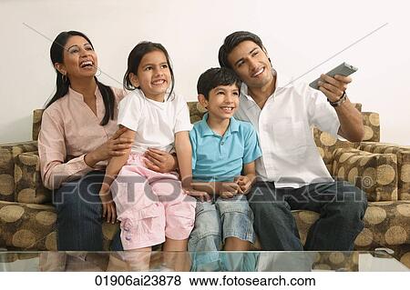 Stock Photo - Family watching tv on couch. Fotosearch