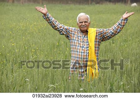 Stock Photo - farmer in field, hands in air. Fotosearch