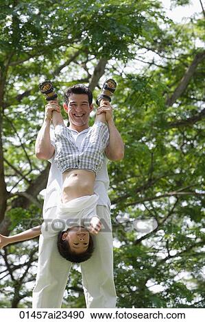 Stock Image - Father and son playing at the park. Fotosearch