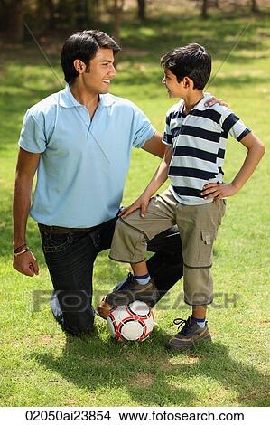 Father and son with foot on soccer ball View Large Photo Image Picture - Father and son with foot on soccer ball. Fotosearch